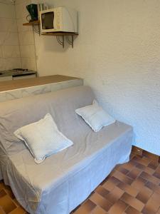 a bed in a room with two pillows on it at Studio Cosy pied des pistes in Saint-Léger-les-Mélèzes