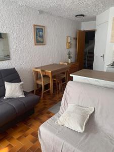 a living room with a couch and a table at Studio Cosy pied des pistes in Saint-Léger-les-Mélèzes