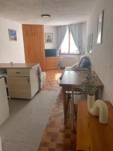 a kitchen and living room with a table and a desk at Studio Cosy pied des pistes in Saint-Léger-les-Mélèzes