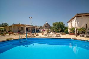 a swimming pool with a patio and a house at WePuglia - Canto dei Grilli in Noci