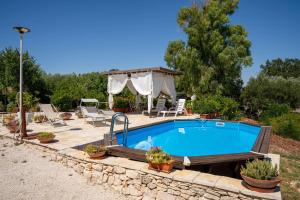 a swimming pool with a patio and a gazebo at WePuglia - Canto dei Grilli in Noci