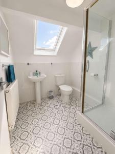 a bathroom with a toilet and a sink and a shower at New Top Floor Large 1- Bed Flat in Morecambe