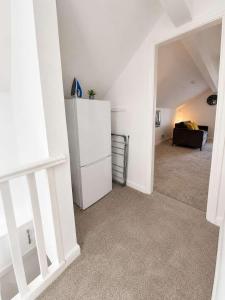 a room with a white refrigerator and a couch at New Top Floor Large 1- Bed Flat in Morecambe +3 photos