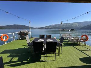 a table and chairs on the deck of a boat at Casa pe lac Bicaz in Bicaz
