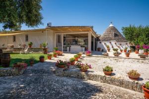 a house with potted plants on the driveway at WePuglia - Canto dei Grilli in Noci +36 photos