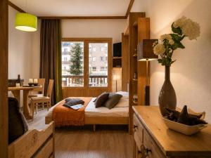 a bedroom with a bed and a vase with flowers on a table at Val d'Isère Centre - Emplacement Idéal in Val-d'Isère