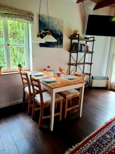 a dining room table with chairs and a book shelf at Ferienhaus am Schulsee in Mölln