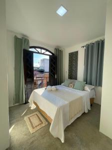 a bedroom with a large bed and a balcony at Hotel Brisa Serrana no Centro de Serrinha in Serrinha