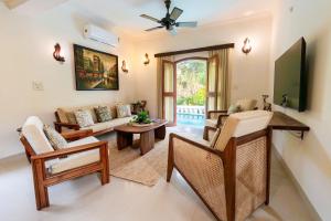 a living room with a couch and a tv at Aguada Anchorage - The Villa Resort, Candolim in Candolim