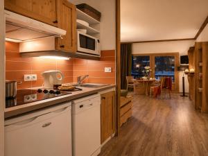 a kitchen with a sink and a microwave at Val d'Isère Centre - Emplacement Idéal in Val-d'Isère