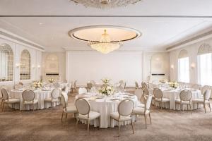 a banquet hall with white tables and chairs and a chandelier at Bristol Berlin, Vignette Collection by IHG in Berlin +157 photos