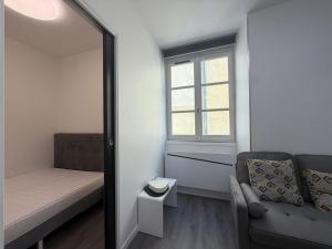 a small room with a couch and a window at La suite Saint Régis 2 in Le Puy-en-Velay