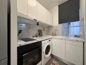 a kitchen with a washing machine and a sink at La suite Saint Régis 2 in Le Puy-en-Velay