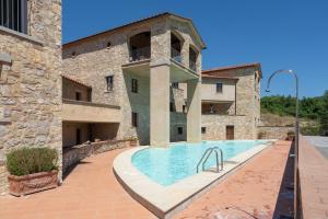 an external view of a building with a swimming pool at Borgo di Gaiole - Casa BD - apartment with a view & travel guide in Gaiole in Chianti