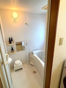 a bathroom with a bath tub and a toilet at Flat Dazaifu in Dazaifu +10 photos