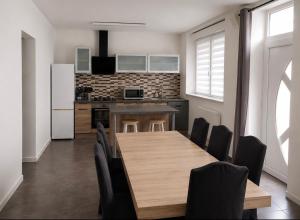 a kitchen with a wooden table and black chairs at WÖRGÖTTER Sandrine in Monthermé