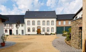 a large white house with a black roof at Hollender Hof in Bongard