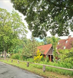 a house with a fence next to a road at Ferienhaus am Schulsee in Mölln