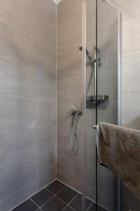 a shower with a glass door in a bathroom at Holiday Hotel Siófok in Siófok +55 photos