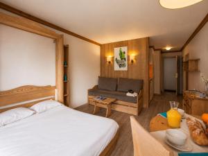 a bedroom with a bed and a couch and a table at Val d'Isère Centre - Emplacement Idéal in Val-d'Isère