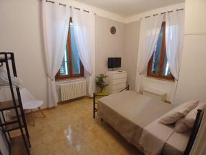 a bedroom with a bed and a tv and windows at Chimera 37's in Avezzano