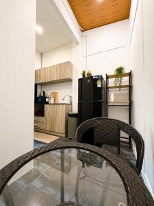 a glass table and chairs in a kitchen with a refrigerator at Jip Studio - 3mn ZenBeach - Garden View in Haad Chao Phao