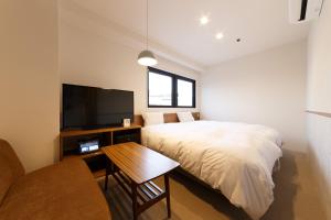 a bedroom with a bed and a flat screen tv at Hotel Citio Shizuoka in Shizuoka