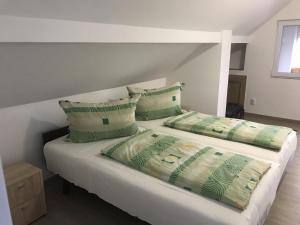 a bedroom with two beds with green and white pillows at Nice Big House in Balatonfenyves +57 photos