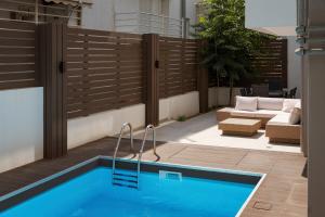 a swimming pool in a backyard with a wooden fence at Alimos Escape 3 in Athens