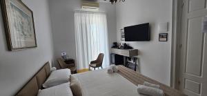 a living room with a table and a couch and a television at Al Corso Charming Rooms in Peschici