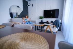 a woman and a child sitting in a living room at Campo Resort in Duszniki Zdrój +41 photos