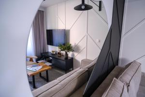 a living room with a couch and a tv at Campo Resort in Duszniki Zdrój