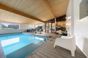 a swimming pool in a house with a wooden ceiling at La villa Grand Ouest in Plounéour-Trez