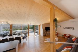 a dining room and living room with wooden ceilings at La villa Grand Ouest in Plounéour-Trez