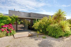 a house with glass doors and some plants and flowers at La villa Grand Ouest in Plounéour-Trez