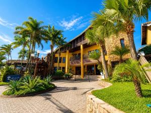 a building with palm trees in front of it at Ilha Flat Apto 3207 in Ilhabela