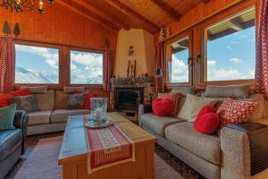 a living room with couches and a fireplace at Chalet Belle Poncke by Jolidi in Nendaz