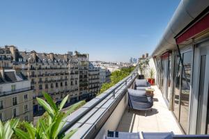 a balcony with chairs and a view of a city at Urban Hive Paris in Paris