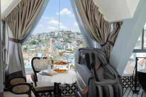 a table and chairs in a room with a window at TTR Skypool View Hotel - Đà lạt in Da Lat