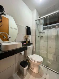 a bathroom with a toilet and a sink and a shower at Apt Moderno e Confortavel 7 min do Centro em 7L in Sete Lagoas