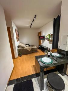 a living room with a table and a bed at Apt Moderno e Confortavel 7 min do Centro em 7L in Sete Lagoas