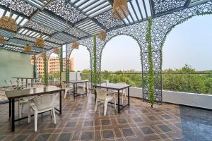 a dining area with tables and chairs and windows at Treebo Park View Villa in Jodhpur
