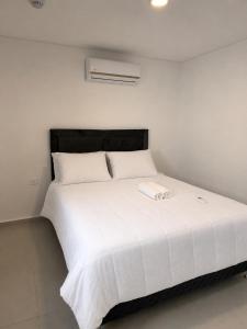 a large white bed in a white room at Práctico y Cómodo Apartamento en Edificio Vivo Costanera in Encarnación +15 photos