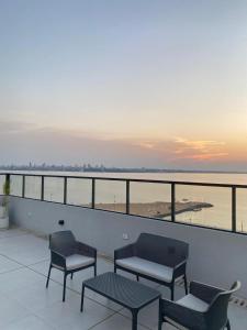 a balcony with chairs and tables and a view of the ocean at Práctico y Cómodo Apartamento en Edificio Vivo Costanera in Encarnación
