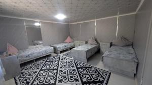 a room with three beds and a mirror at Koch Iz guest house in Kochkorka
