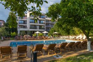 a swimming pool with chairs and a building at Hotel Central in Sunny Beach