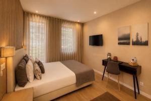 a bedroom with a bed and a desk and a television at MyTrip Porto in Matosinhos