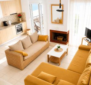a living room with a couch and a fireplace at E&M Villa Sea View II in Polychrono +15 photos