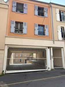 a building with two garage doors with windows at Studio idéal Gare & Centre-Ville in Conflans-Sainte-Honorine