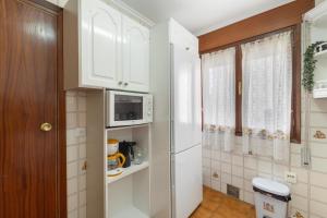 a kitchen with white cabinets and a white refrigerator at La Casona de Sacramenia in Sacramenia +24 photos